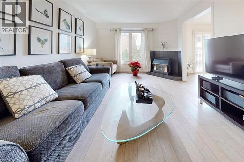 Living room with light wood-type flooring and a fireplace - 62 Como Place, Hamilton, ON - Indoor Photo Showing Living Room With Fireplace