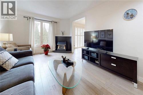 Living area with light wood-type flooring and a tile fireplace - 62 Como Place, Hamilton, ON - Indoor Photo Showing Living Room With Fireplace