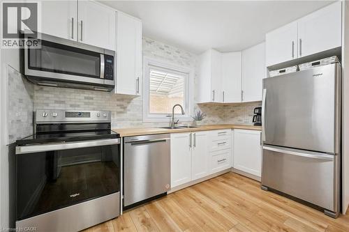 Kitchen featuring butcher block countertops, stainless steel appliances, and white cabinetry - 699 Frederick Street, Kitchener, ON - Indoor Photo Showing Kitchen With Stainless Steel Kitchen With Double Sink