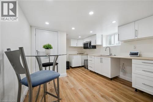 Kitchen with white cabinetry, light countertops, light wood-style floors, recessed lighting, and stainless steel microwave - 699 Frederick Street, Kitchener, ON - Indoor