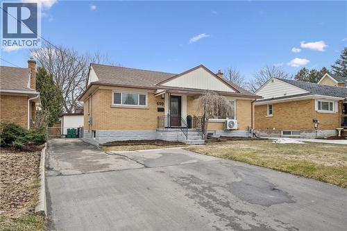 Bungalow-style home featuring brick siding, a shingled roof, and a chimney - 699 Frederick Street, Kitchener, ON - Outdoor With Facade