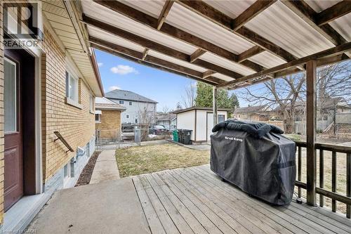Wooden deck with a grill, a residential view, an outbuilding, and a gate - 699 Frederick Street, Kitchener, ON - Outdoor With Deck Patio Veranda With Exterior