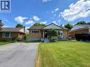 Traditional brick exterior with a pitched shingle roof, featuring a front porch with steps and a manicured lawn - 699 Frederick Street, Kitchener, ON 
