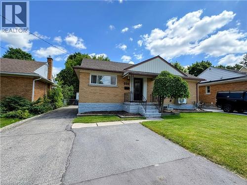 Brick exterior featuring a covered front entry with dark railings - 699 Frederick Street, Kitchener, ON 