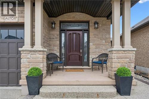 Entrance to property featuring a porch, stone siding, and a garage - 469 Woodbine Avenue, Kitchener, ON - Outdoor