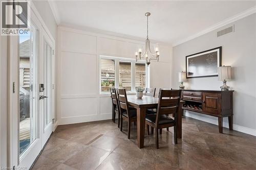 Dining area featuring a decorative wall, ornamental molding, plenty of natural light, and a chandelier - 469 Woodbine Avenue, Kitchener, ON - Indoor Photo Showing Dining Room