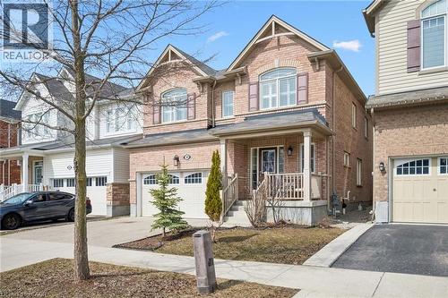Craftsman-style house featuring covered porch, brick siding, an attached garage, and driveway - 38 Park Glen Street, Kitchener, ON - Outdoor With Facade