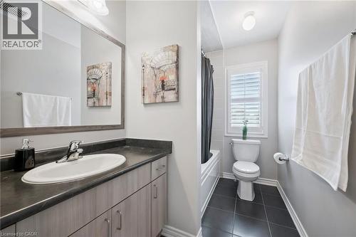 Bathroom featuring vanity, dark tile patterned floors, and shower / bathtub combination with curtain - 38 Park Glen Street, Kitchener, ON - Indoor Photo Showing Bathroom