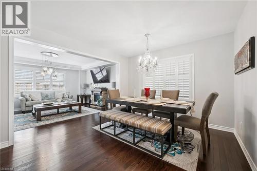 Dining area featuring hanging lights, dark wood-type flooring, and a stone fireplace - 38 Park Glen Street, Kitchener, ON - Indoor