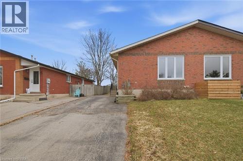 View of property exterior with a yard, brick siding, entry steps, and driveway - 7 Forest Drive, Paris, ON - Outdoor With Exterior