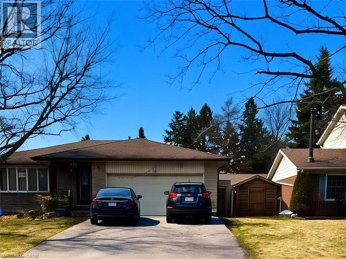 View of front of house with an attached garage, driveway, a shed, a front lawn, and brick siding - 416 Warrington Drive, Waterloo, ON - Outdoor