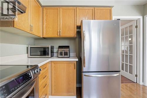 Kitchen with stainless steel appliances, light countertops, and light wood finished floors - 18 Webster Way, Georgetown, ON - Indoor Photo Showing Kitchen