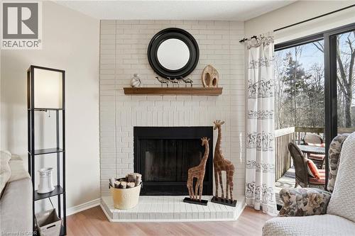 Living room featuring a fireplace and light wood-type flooring - 18 Webster Way, Georgetown, ON - Indoor Photo Showing Living Room With Fireplace