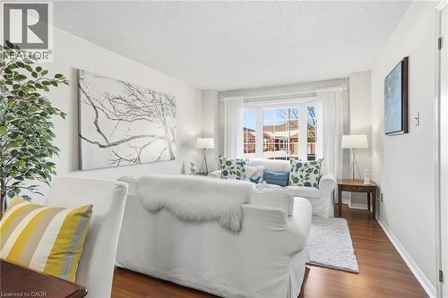 Living room featuring a textured ceiling and dark wood-style flooring - 18 Webster Way, Georgetown, ON - Indoor Photo Showing Living Room