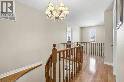 Hall with an upstairs landing, light wood-style flooring, a chandelier, and a textured ceiling - 18 Webster Way, Georgetown, ON - Indoor Photo Showing Other Room