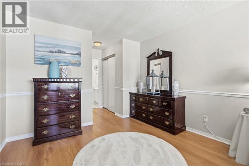 Bedroom with a closet, light wood-type flooring, and a textured ceiling - 18 Webster Way, Georgetown, ON - Indoor Photo Showing Bedroom