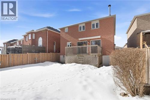 Snow covered house with a wooden deck and brick siding - 18 Webster Way, Georgetown, ON - Outdoor With Exterior