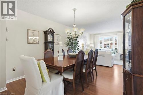 Dining room featuring dark wood finished floors, suspended lighting, and a textured ceiling - 18 Webster Way, Georgetown, ON - Indoor Photo Showing Dining Room