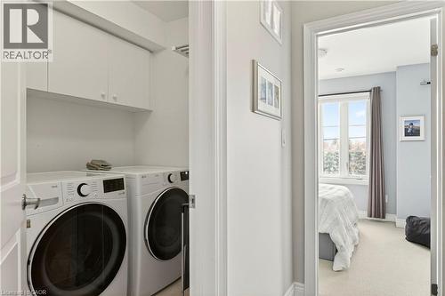 Laundry room with separate washer and dryer, cabinet space, and light colored carpet - 1862 Burnhamthorpe Road, Mississauga, ON - Indoor Photo Showing Laundry Room
