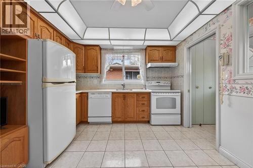 Kitchen with wood finish cabinets, white appliances, light countertops, a ceiling fan, and light tile patterned floors - 21 Bluebird Avenue, Hamilton, ON - Indoor Photo Showing Kitchen