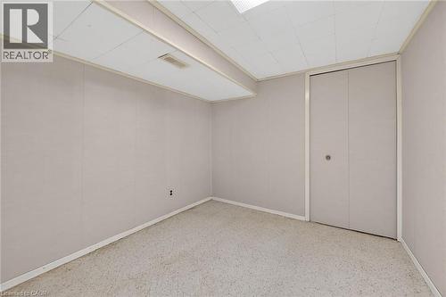 Unfurnished bedroom featuring dark speckled floor and a closet - 21 Bluebird Avenue, Hamilton, ON 