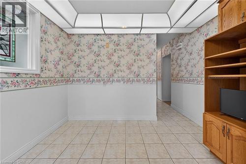 Spare room featuring a wainscoted wall, light tile patterned floors, and wallpapered walls - 21 Bluebird Avenue, Hamilton, ON - Indoor Photo Showing Other Room