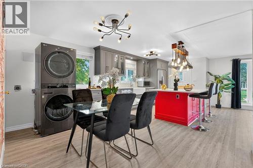 Dining room featuring light wood-type flooring, a chandelier, and stacked washer / dryer - 146 Appalachian Crescent Unit# Upper, Kitchener, ON - Indoor Photo Showing Laundry Room