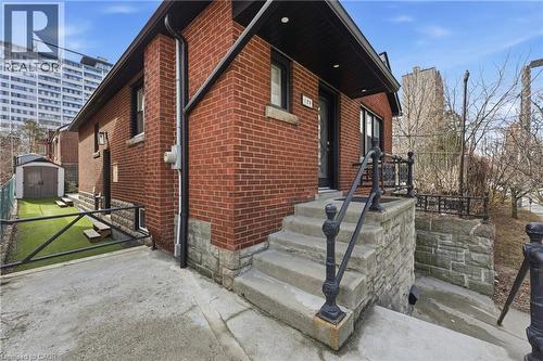 View of property exterior featuring brick siding and a shed - 129 Jackson Street W, Hamilton, ON - Outdoor