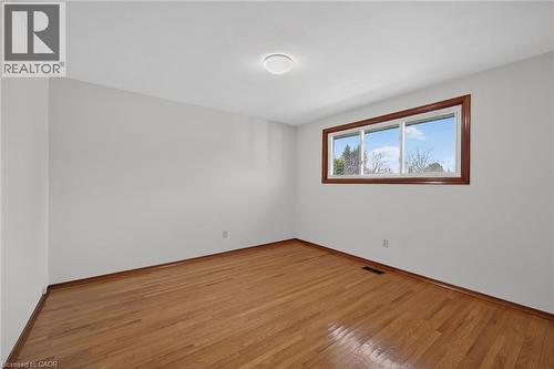 Empty room with wood-type flooring and baseboards - 122 Glen Forest Drive, Hamilton, ON - Indoor Photo Showing Other Room