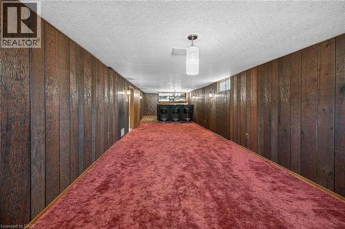 Finished below grade area with carpet flooring, wood walls, and a textured ceiling - 122 Glen Forest Drive, Hamilton, ON - Indoor Photo Showing Other Room