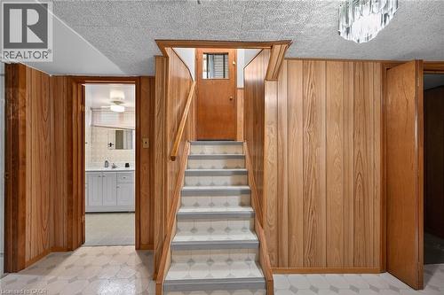 Staircase with tile patterned floors and wooden walls - 122 Glen Forest Drive, Hamilton, ON - Indoor Photo Showing Other Room