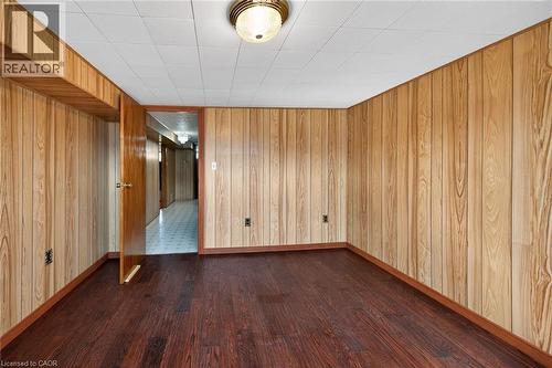 Unfurnished room with dark wood-type flooring and wood walls - 122 Glen Forest Drive, Hamilton, ON - Indoor Photo Showing Other Room