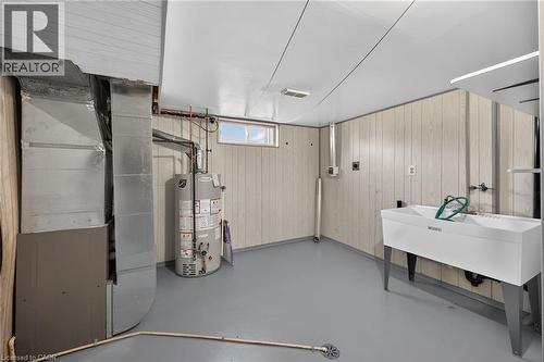 Below grade area with heating unit, wooden walls, and water heater - 122 Glen Forest Drive, Hamilton, ON - Indoor