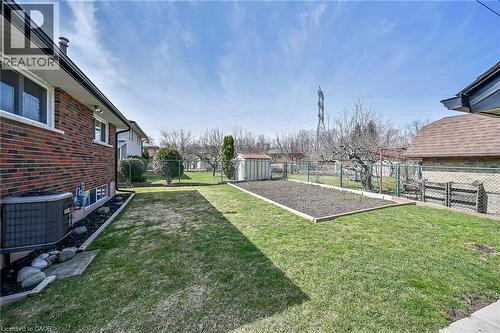 Fenced backyard featuring a storage unit and a vegetable garden - 122 Glen Forest Drive, Hamilton, ON - Outdoor With Exterior