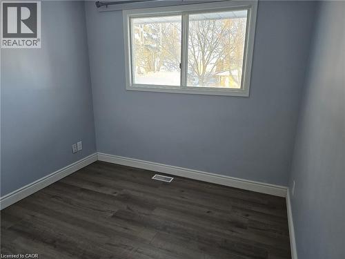 Unfurnished room with dark wood-type flooring and baseboards - 593 Mount Anne Drive, Waterloo, ON - Indoor Photo Showing Other Room