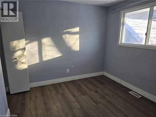 Spare room featuring baseboards and dark wood-type flooring - 593 Mount Anne Drive, Waterloo, ON - Indoor Photo Showing Other Room