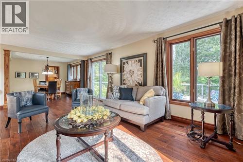 Living area with dark wood-style flooring, hanging lights, and a textured ceiling - 15 Marquette Drive, Kitchener, ON - Indoor Photo Showing Living Room