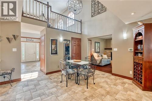 Dining area featuring stone finish floors, suspended lighting, a high ceiling, and a fireplace - 15 Marquette Drive, Kitchener, ON - Indoor