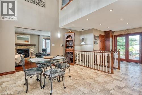 Dining area featuring a stone fireplace, stone finish flooring, recessed lighting, french doors, and a high ceiling - 15 Marquette Drive, Kitchener, ON - Indoor