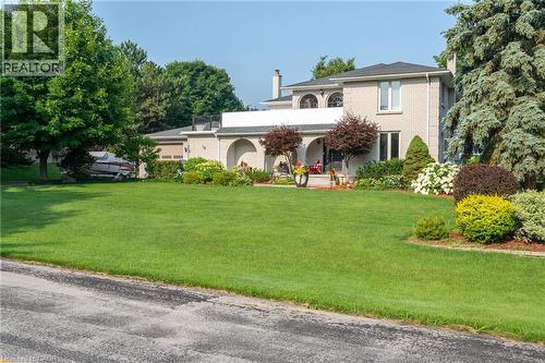 View of front of property featuring a chimney, a front lawn, brick siding, and a porch - 15 Marquette Drive, Kitchener, ON - Outdoor