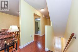 Hall featuring an upstairs landing and wood finished floors - 
