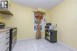 Kitchen with stainless steel range with electric cooktop, white microwave, and light countertops - 