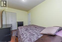 Bedroom with dark wood-type flooring and a closet - 