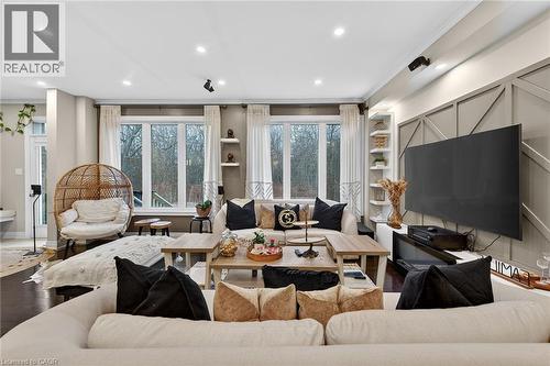 Living area with wood finished floors, crown molding, plenty of natural light, recessed lighting, and built in features - 7809 Hackberry Trail E, Niagara Falls, ON - Indoor Photo Showing Living Room
