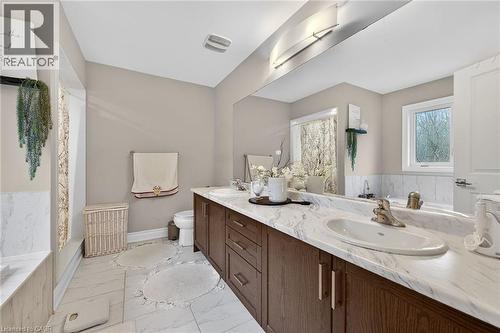 Full bath with a bath, double vanity, and light marble finish floors - 7809 Hackberry Trail E, Niagara Falls, ON - Indoor Photo Showing Bathroom