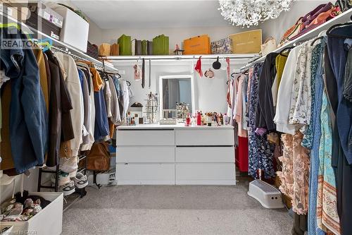 Walk in closet with light colored carpet and hanging lights - 7809 Hackberry Trail E, Niagara Falls, ON - Indoor With Storage