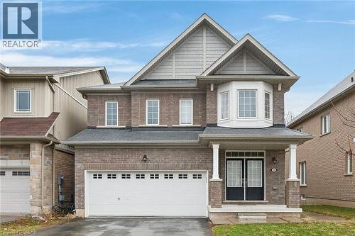 Craftsman house with driveway, covered porch, brick siding, and an attached garage - 7809 Hackberry Trail E, Niagara Falls, ON - Outdoor With Facade