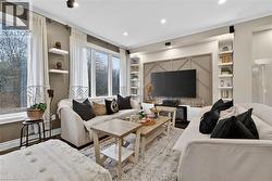 Living room with built in shelves, wood finished floors, ornamental molding, and recessed lighting - 