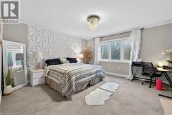 Bedroom featuring crown molding, light carpet, and an accent wall - 