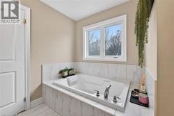 Bathroom featuring a bath and light marble finish flooring - 